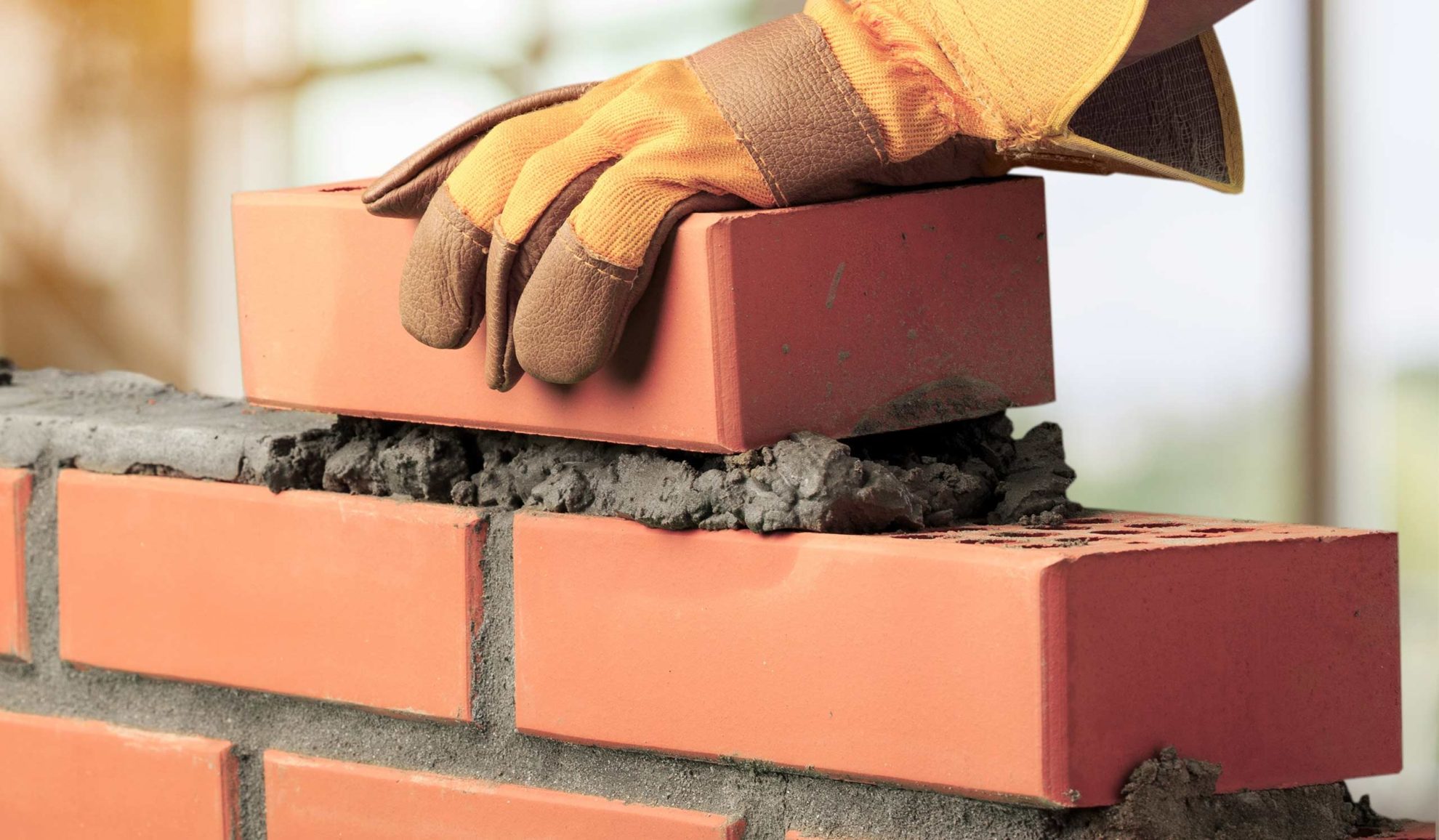 contractor hand close up with gloves building a masonry brick wall blue ridge mo