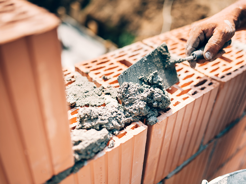 contractor hand with trowel close up building a masonry brick wall blue ridge mo