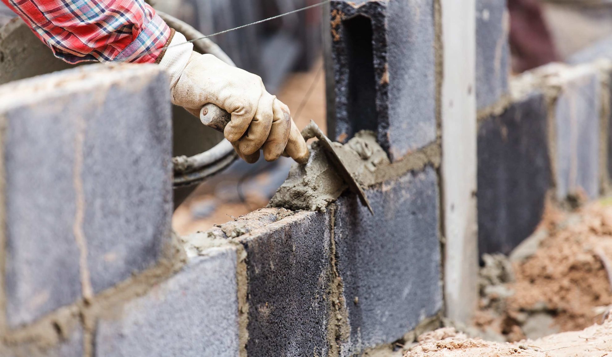 contractor hands close up using trowel and cement to build a concrete bricks wall blue ridge mo